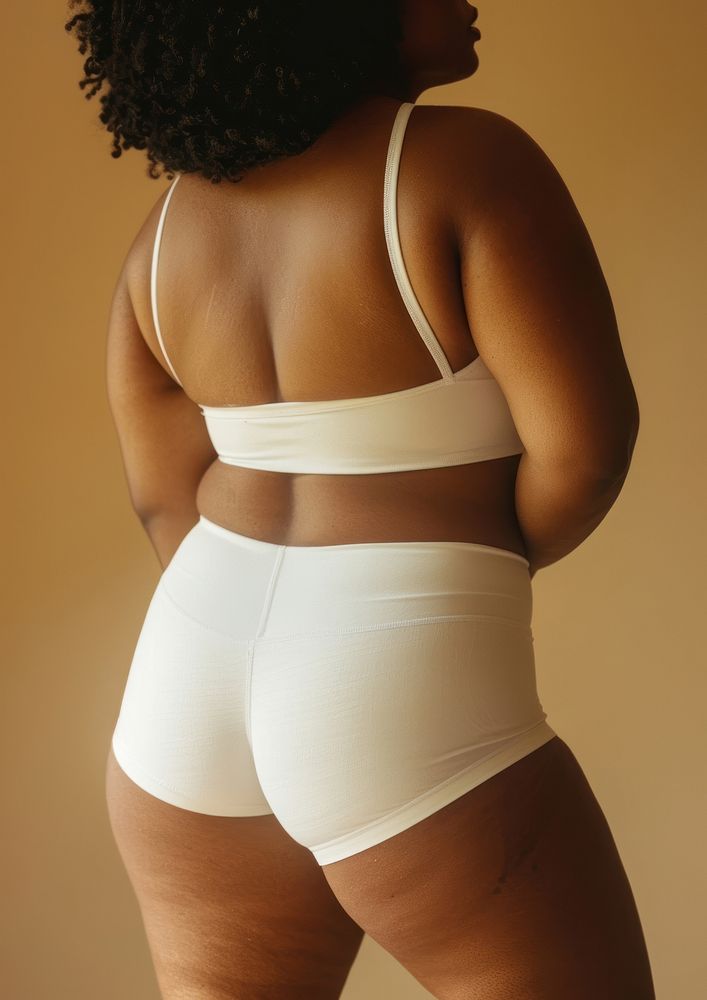 African american chubby woman in white activewear back underwear clothing.