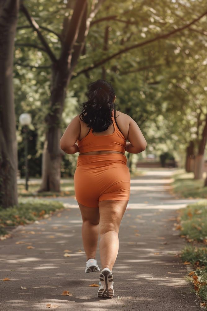 Asian chubby woman in back in brick orange activewear with cellulite skin clothing footwear running.