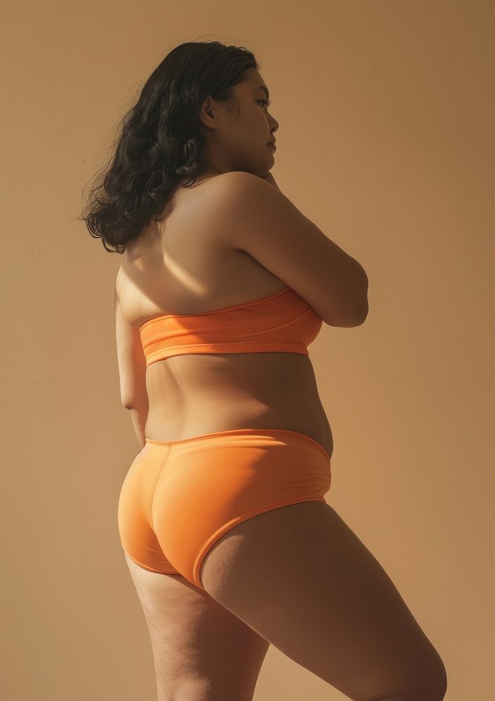 Asian chubby woman in brick orange activewear back underwear clothing.