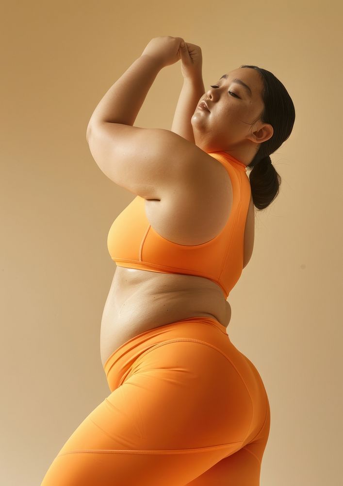 Asian chubby woman in brick orange activewear exercise fitness female.