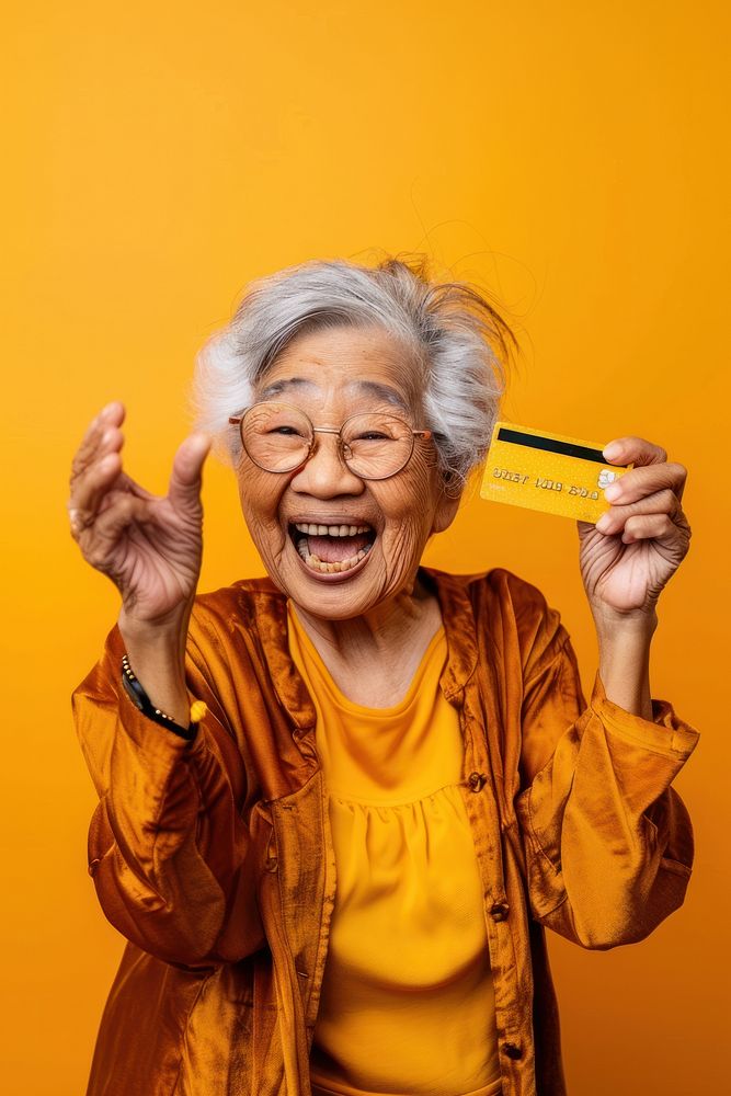 Old asian lady showing credit card happy background expression.