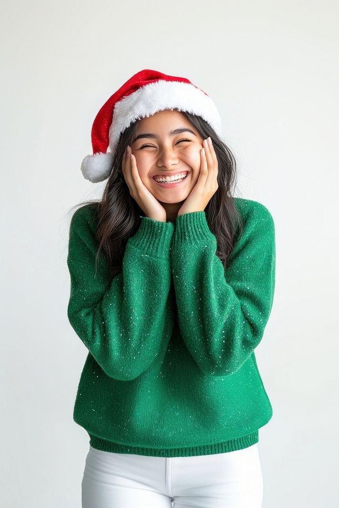 Happy south asian woman in a green sweater and Christmas hat winks christmas smiling holiday.