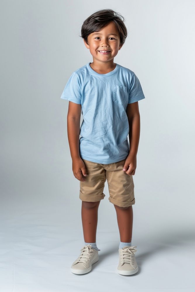 Mix race boy standing shorts shirt.