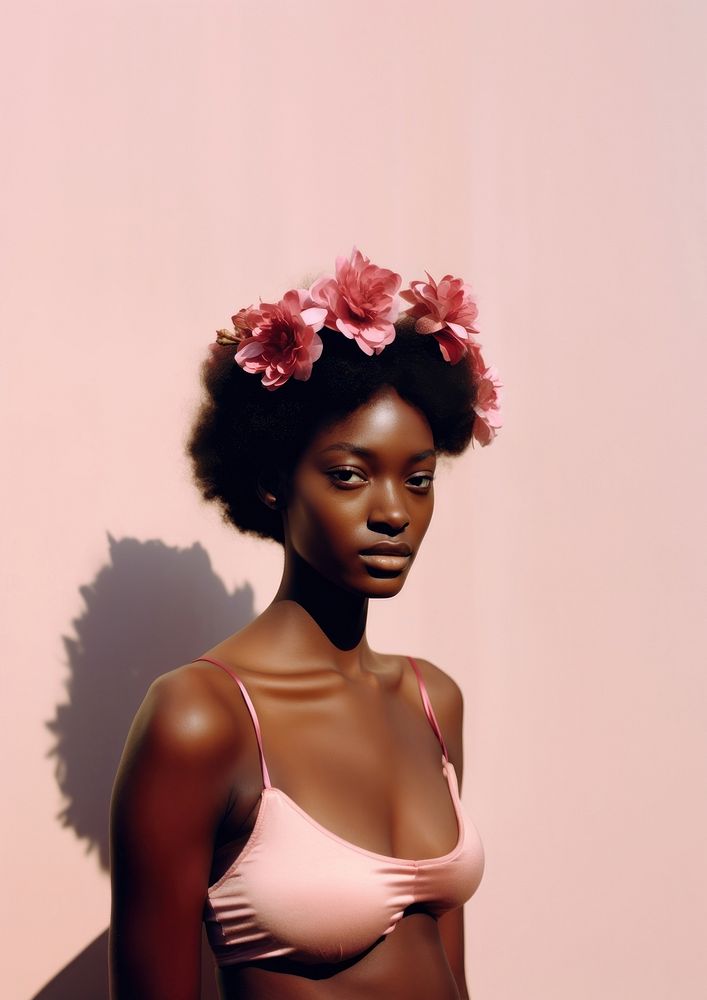 A black teenage woman with a pink flowers on her head fashion photography portrait.