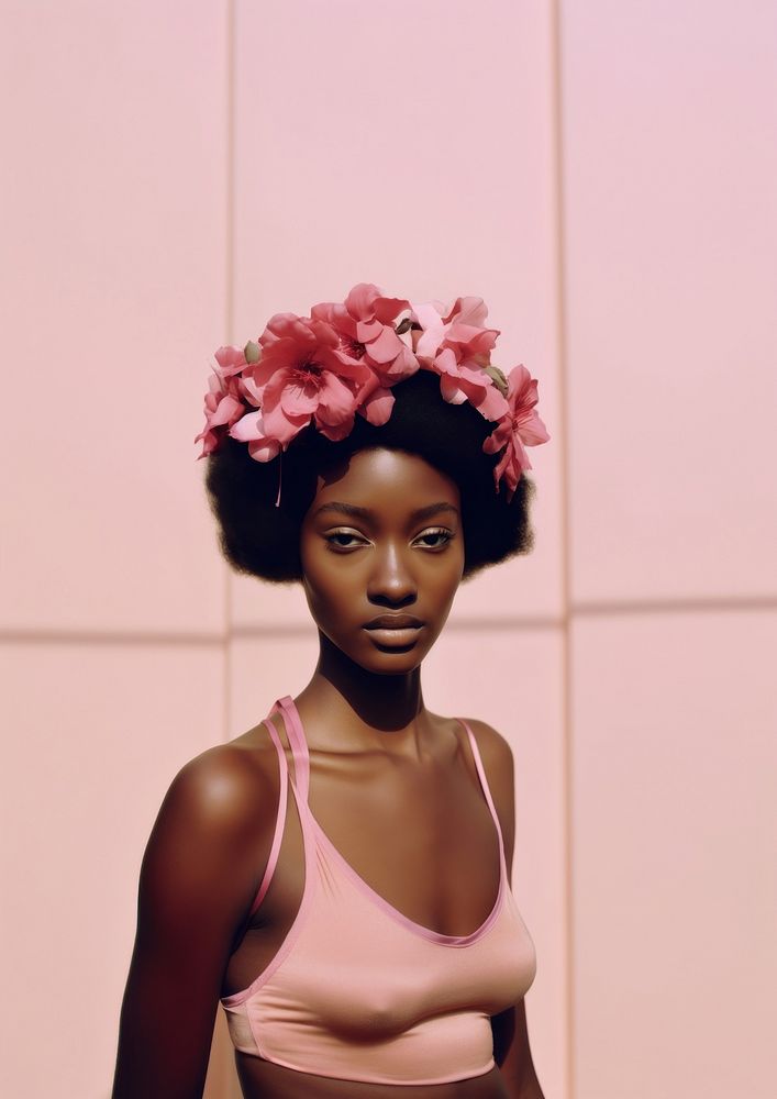 A black teenage woman with a pink flowers on her head photography portrait fashion.