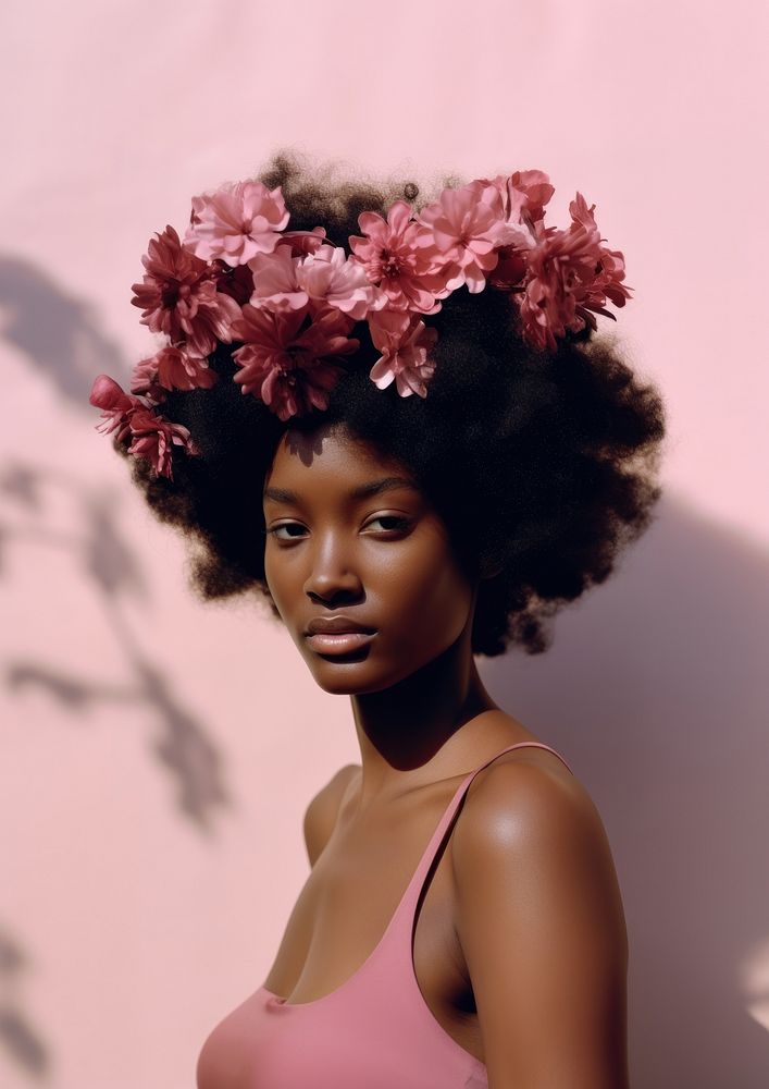 A black teenage woman with a pink flowers on her head photography portrait fashion.