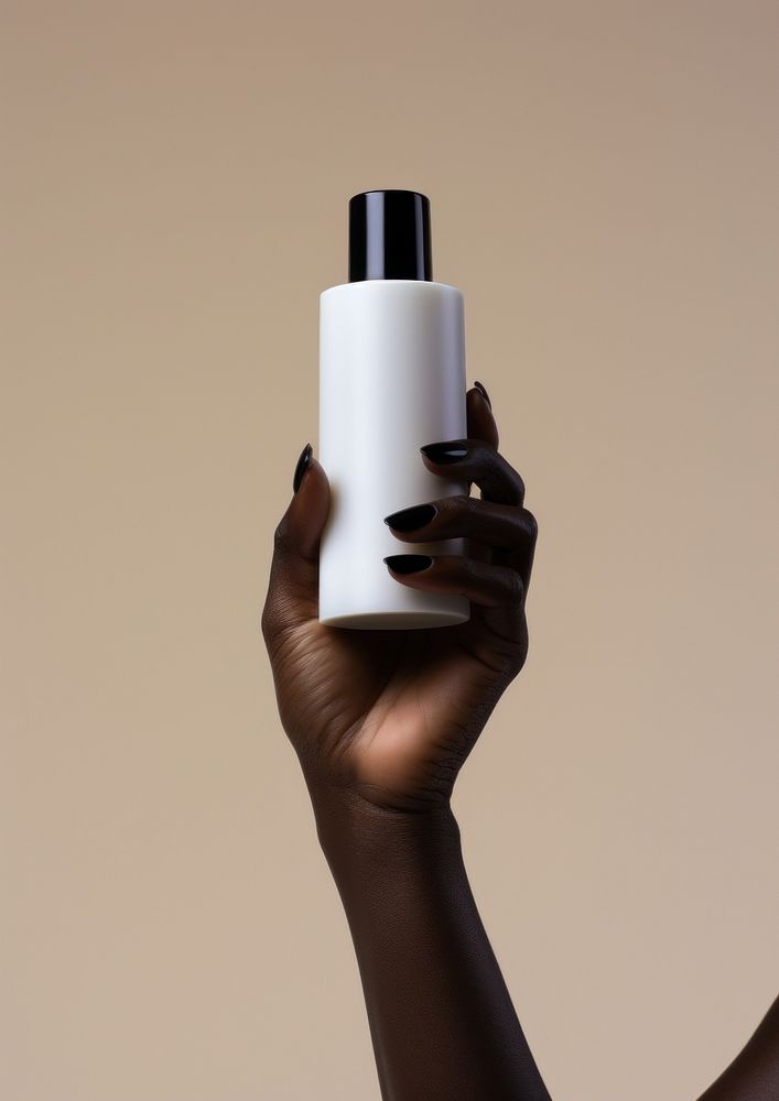 A black woman hand carry a skincare bottle finger cosmetics lighting.