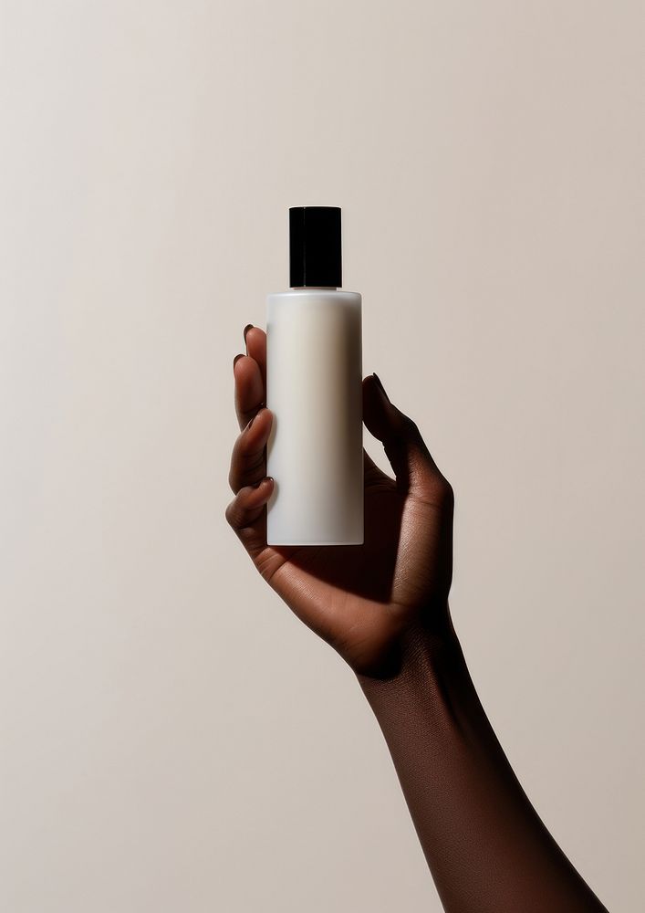A black woman hand carry a skincare bottle cosmetics container holding.