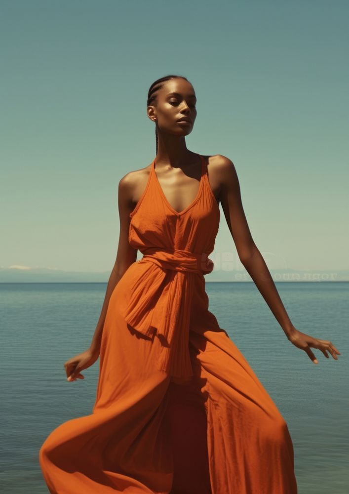 A black woman wearing orange modern minimal cloth fashion photography portrait.