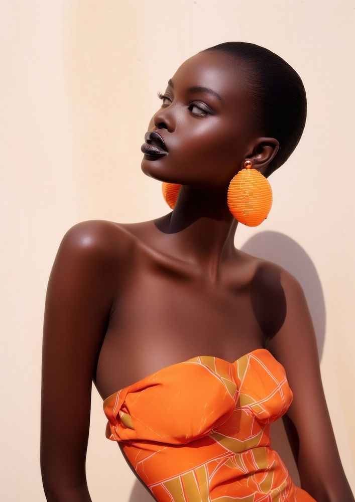 A black woman wearing orange lip and orange earring and orange clothe photography portrait fashion.