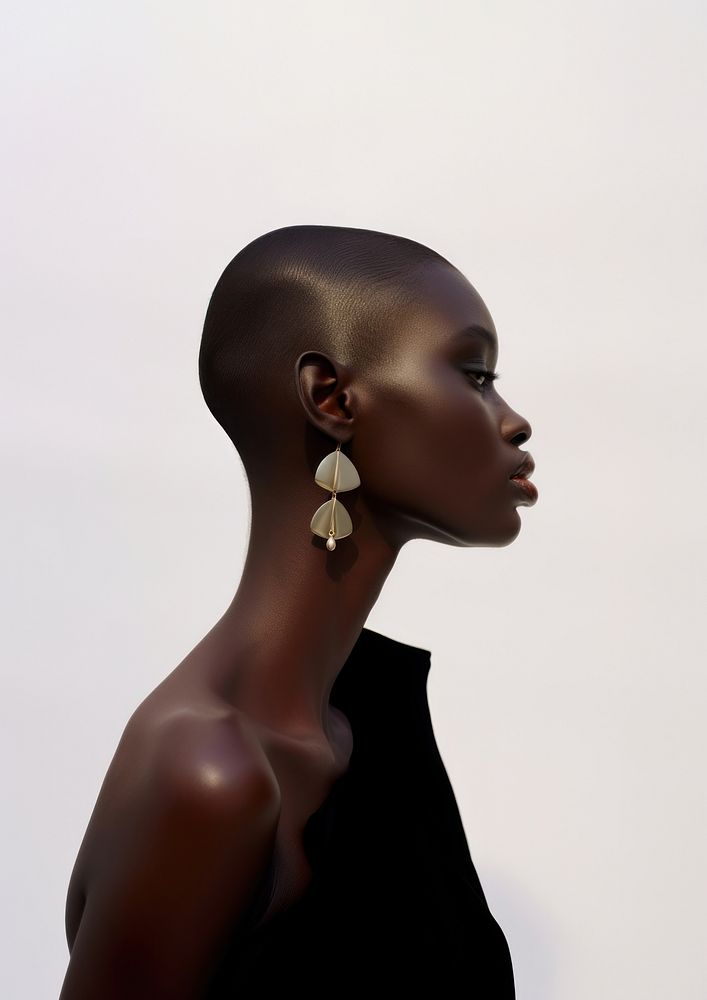 A black woman wearing modern minimal earring looking down the floor jewelry fashion adult.