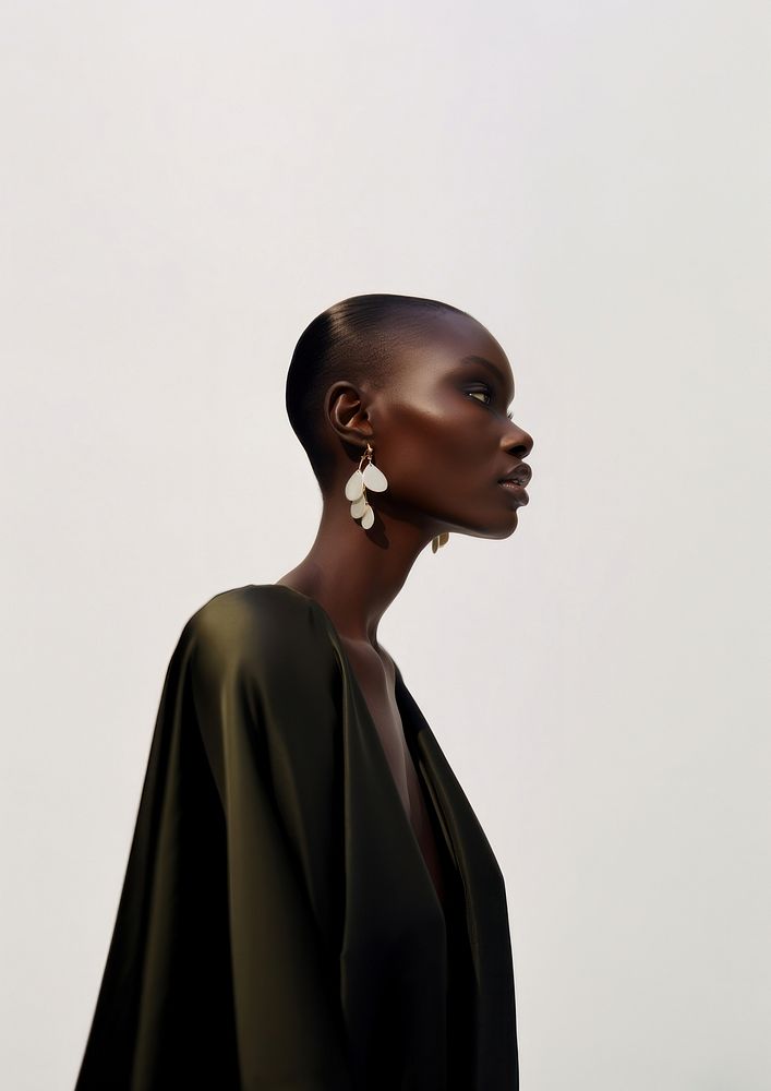 A black woman wearing modern minimal earring looking down photography portrait jewelry.