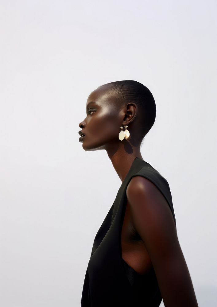 A black woman wearing modern minimal earring looking down photography portrait fashion.