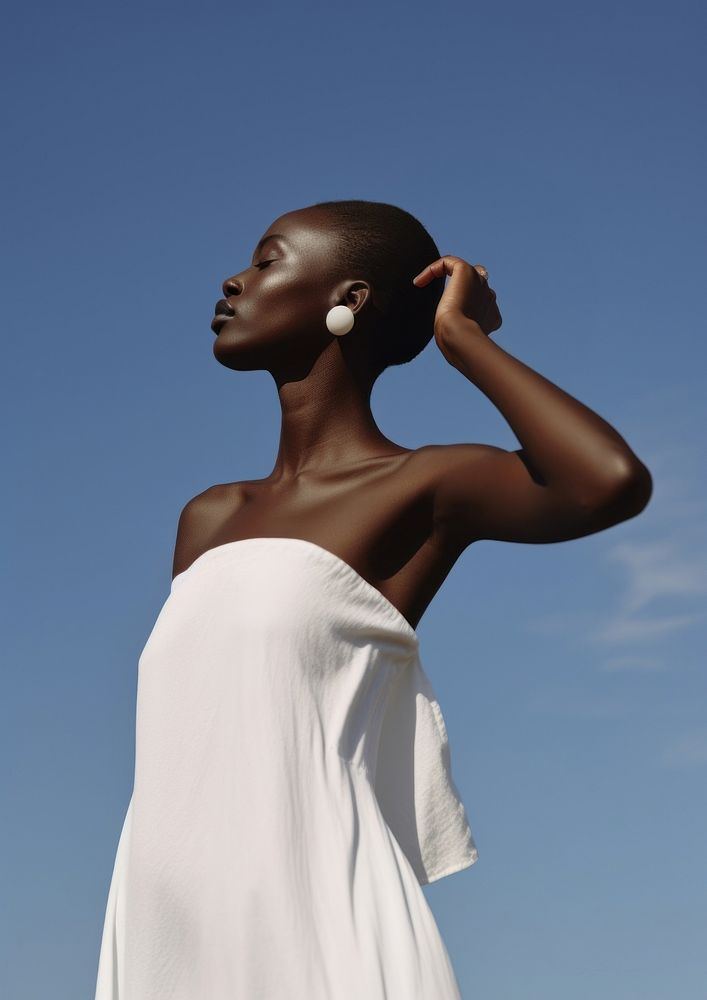 A black woman wearing minimal white dress fashion adult sky.