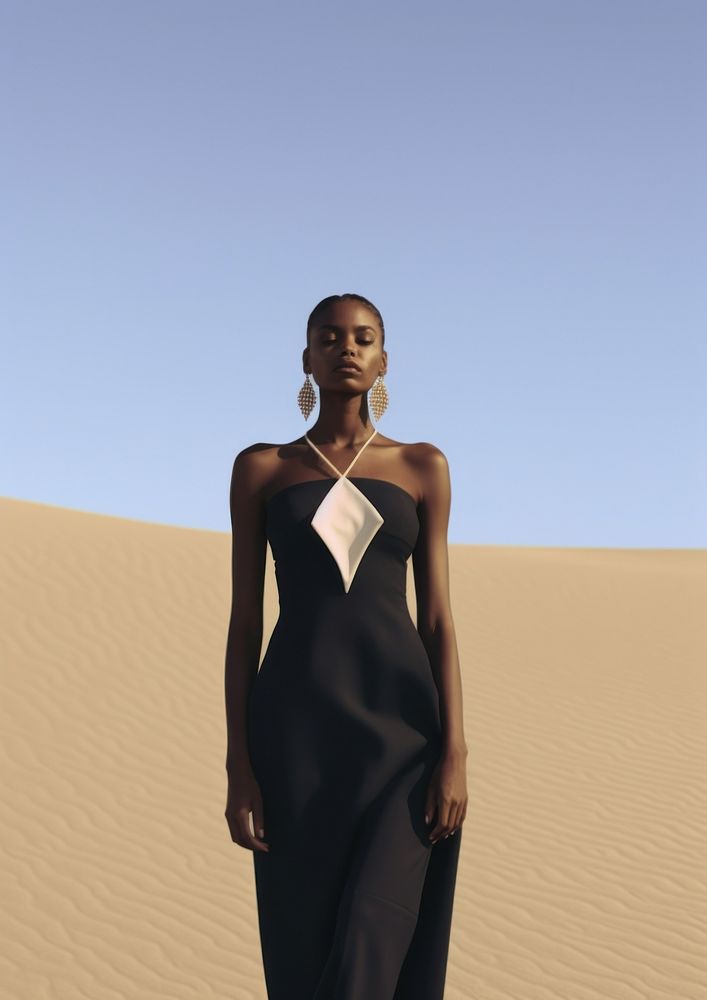 A black woman wearing minimal modern cloth standing in the middle of the desert fashion photography outdoors.