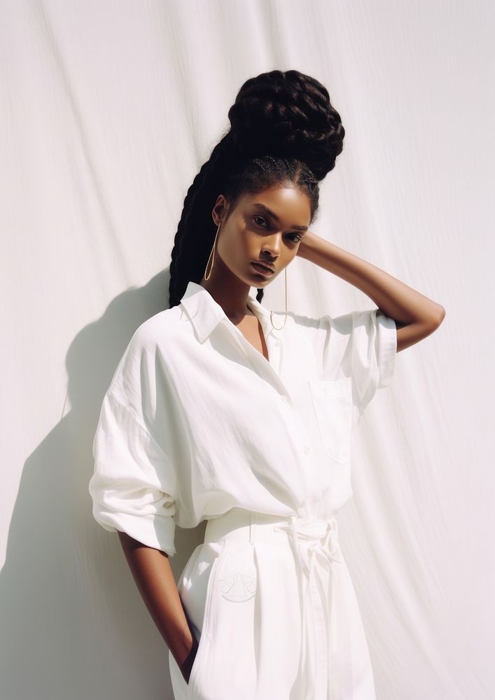 A black woman wearing white modern minimal cloth and modern hairstyle fashion photography portrait.