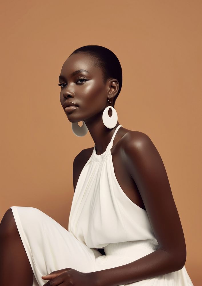 A black woman wearing white minimal dress and white minimal earring photography portrait jewelry.