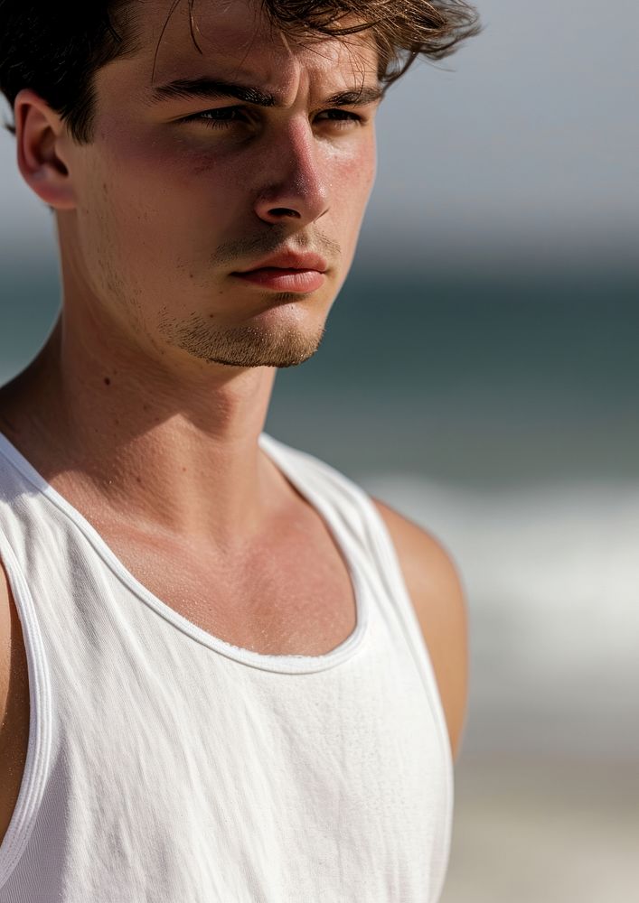 Man wearing white tank top summer beach contemplation.