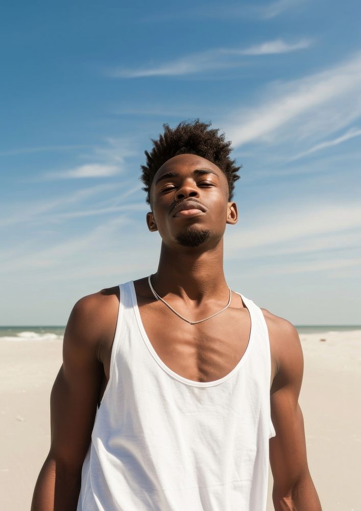 Black man wearing white tank top beach contemplation tranquility.