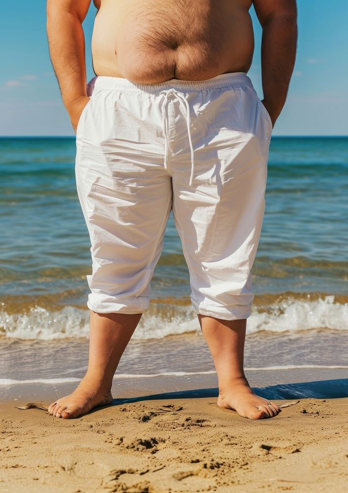Fat man wearing white pants summer shorts beach.