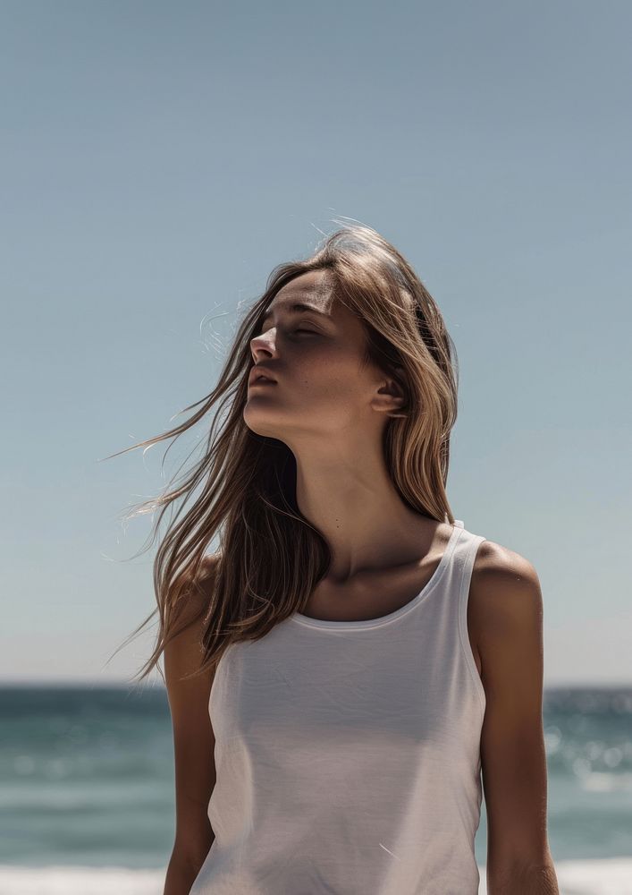 Woman wearing white tank top summer beach contemplation.