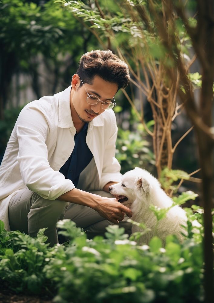 Japanese man playing with a pet portrait outdoors sitting.