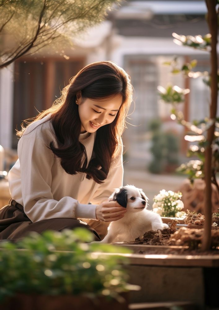 Korean woman playing with a pet portrait outdoors sitting.