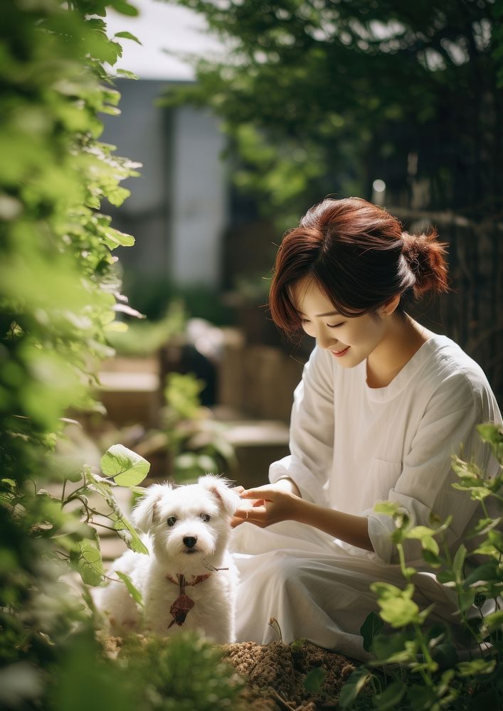 Korean woman playing with a pet outdoors portrait sitting.