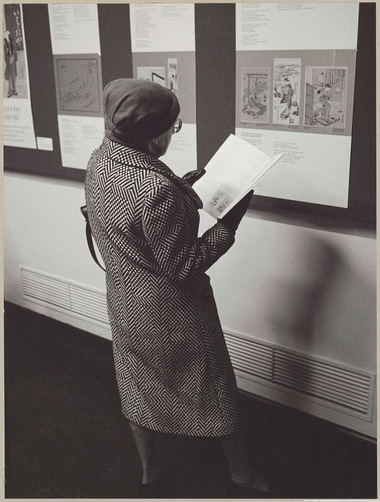 Bezoekster bekijkt de catalogus voor een presentatie aan de wand (c. 1977 - c. 1978) by Rijksmuseum Afdeling Beeld