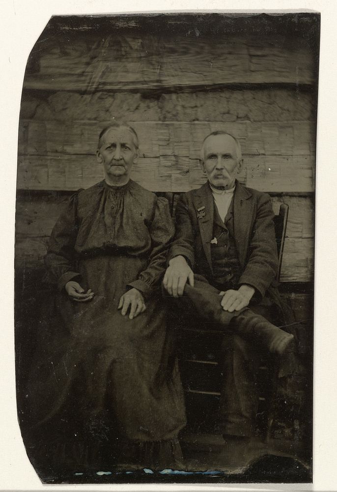 Portret van een oudere man en vrouw, zittend voor een houten muur of schutting (c. 1860 - c. 1900) by anonymous