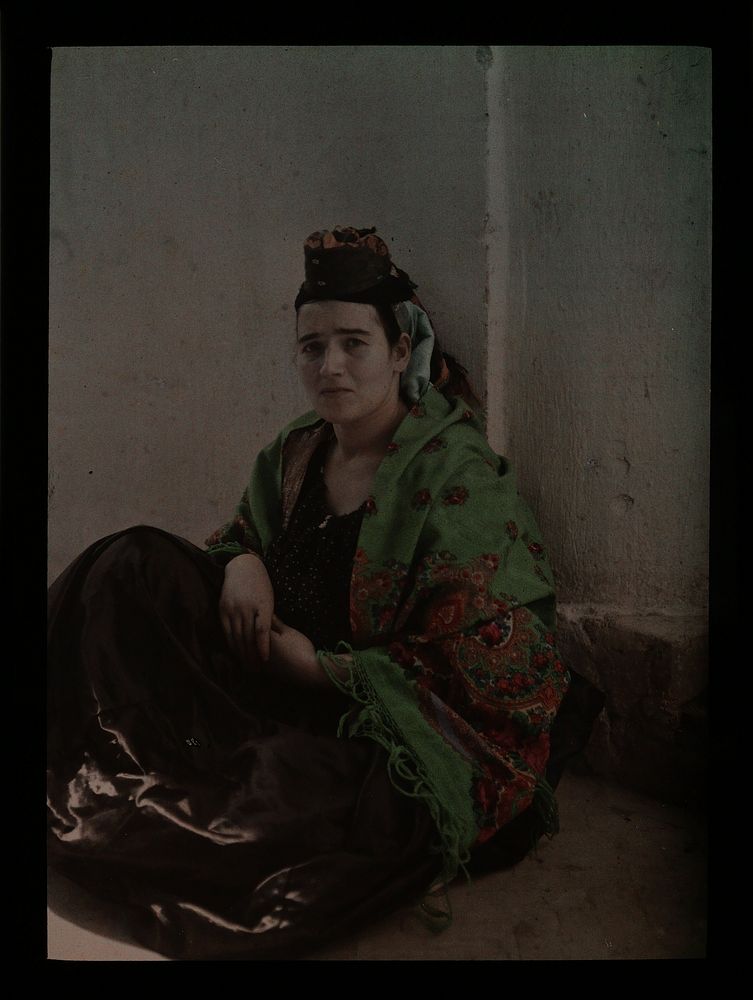 Orientaals geklede vrouw zittend op haar hurken (c. 1910 - c. 1940) by anonymous