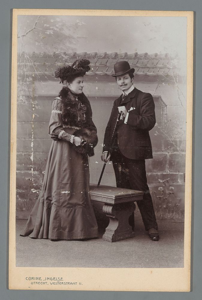 Portret van een onbekende man en vrouw in kleding voor buiten met een mof en een wandelstok (c. 1898 - c. 1912) by Corine…