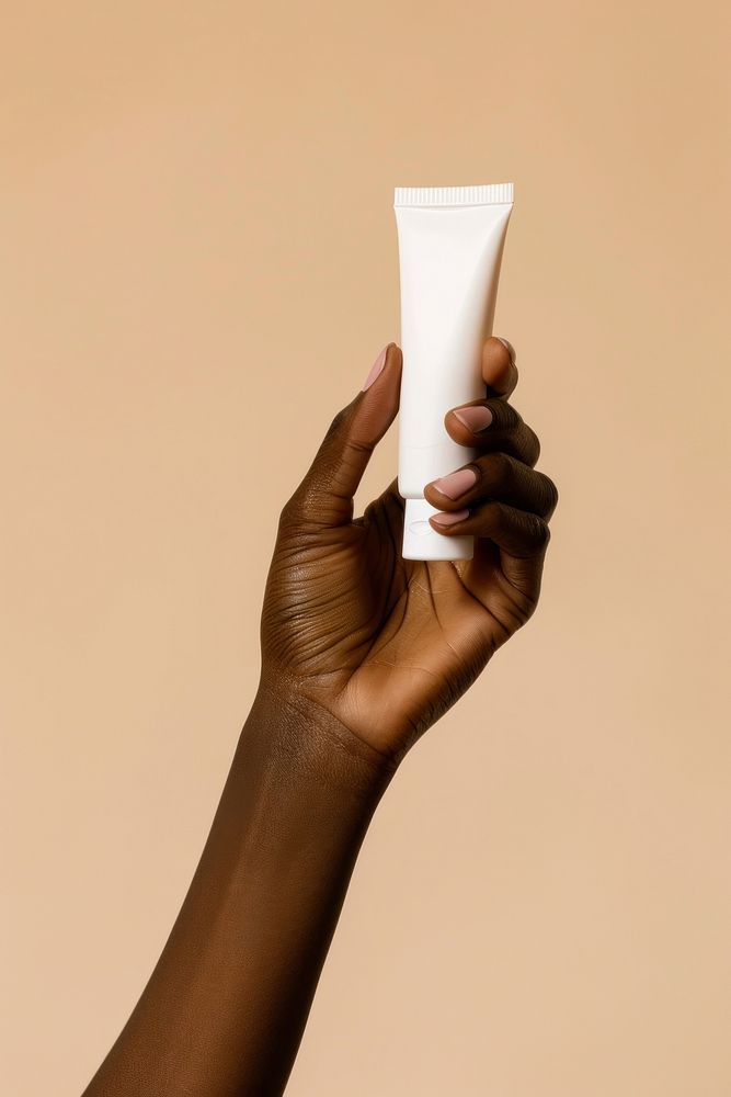 Hand holding cream tube finger adult cosmetics.