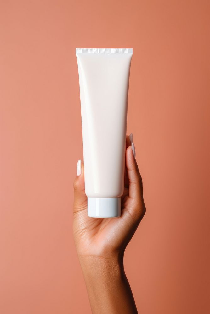 Holding squeeze plastic tube container of cream cosmetics hand skin.