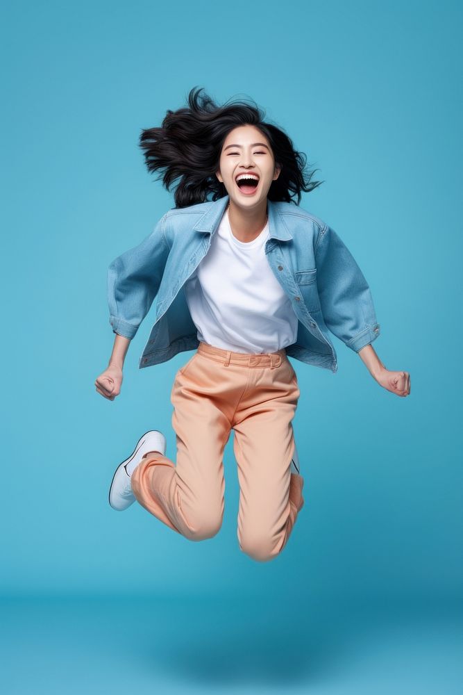 Young Chinese woman full-length jumping shouting smiling adult.