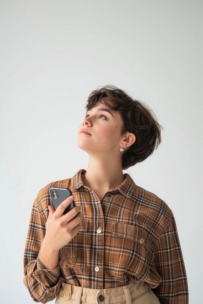 Young latina woman hoding smart phone portrait plaid shirt.