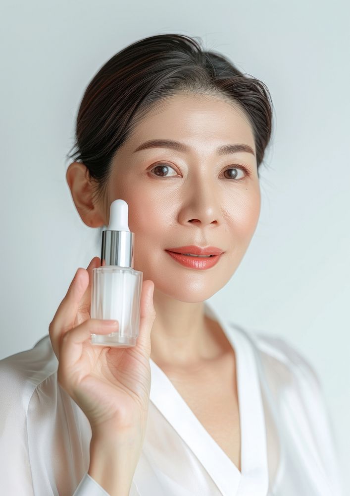 Middle age woman holding a skincare bottle cosmetics lipstick portrait.
