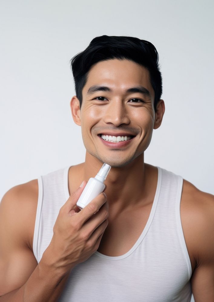 Man holding a skincare bottle cosmetics portrait smile.