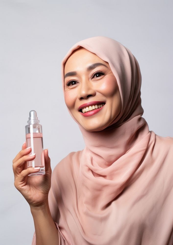 Middle age woman holding a skincare bottle cosmetics portrait photo.