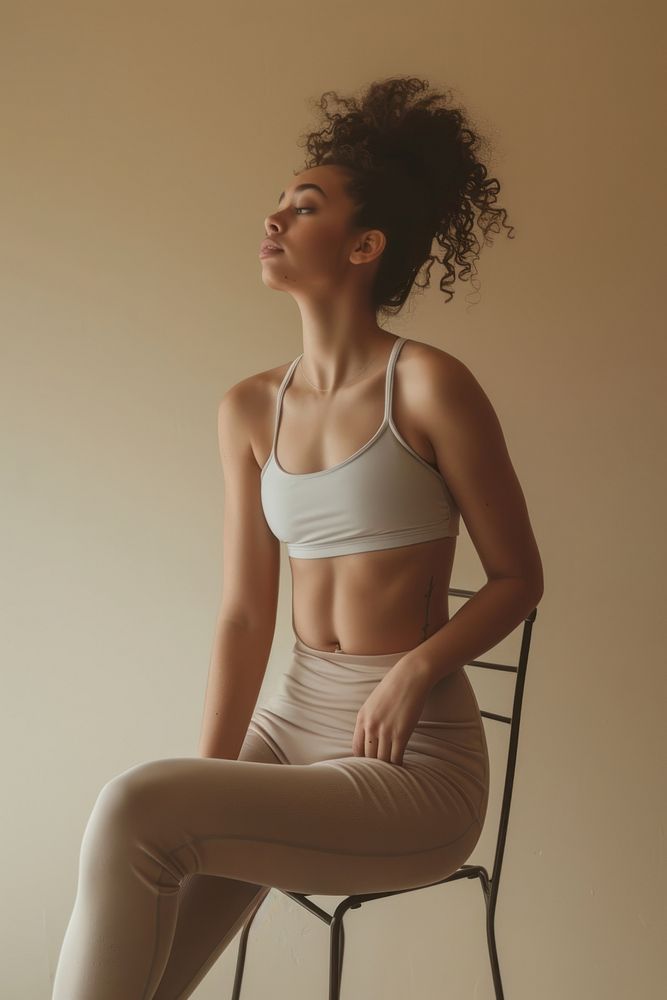 Skinny woman waist wearing exercise pants sitting portrait white.