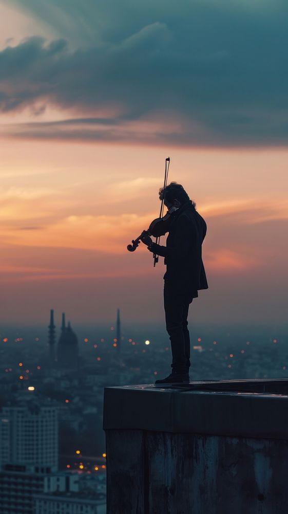  Musician playing violin at the rooftop architecture backlighting cityscape. AI generated Image by rawpixel.