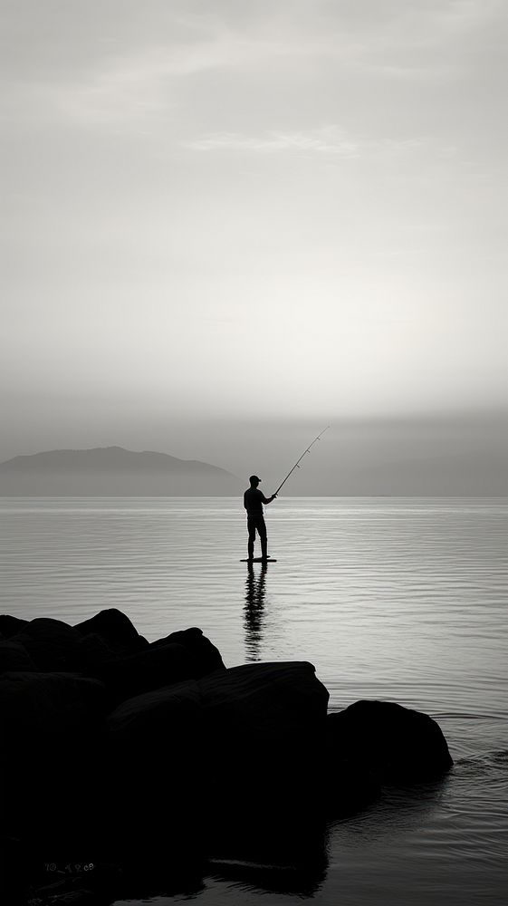 Man fishing at ocean silhouette monochrome outdoors.