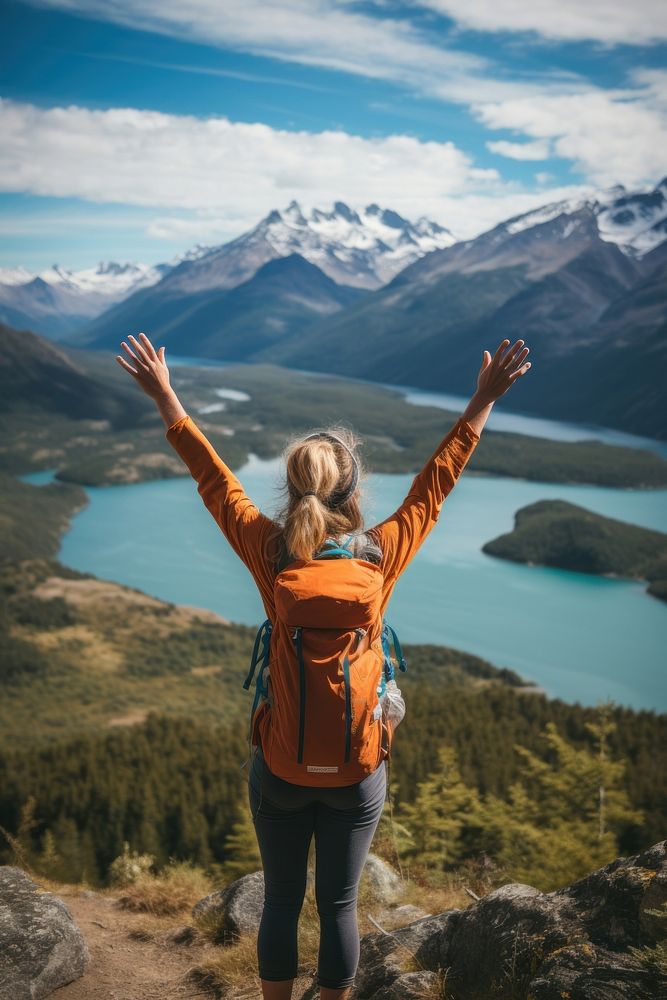 Woman in back raising arms at patagonia hiking backpacking adventure.