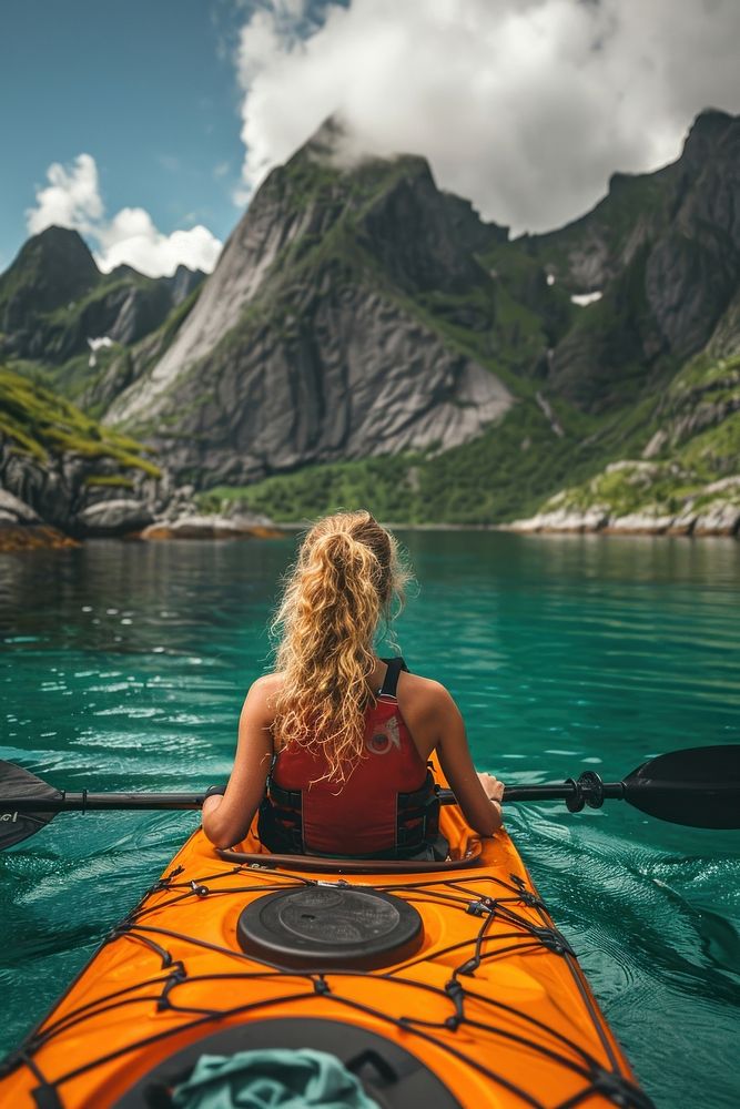 Woman kayaking at Lofoten Archipelago recreation vehicle summer.