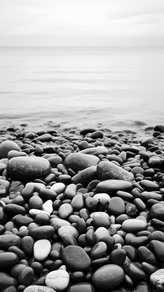 Photography of ocean with beach and stones monochrome pebble rock.