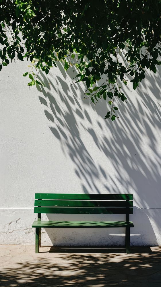 A green bench shadow wall architecture.