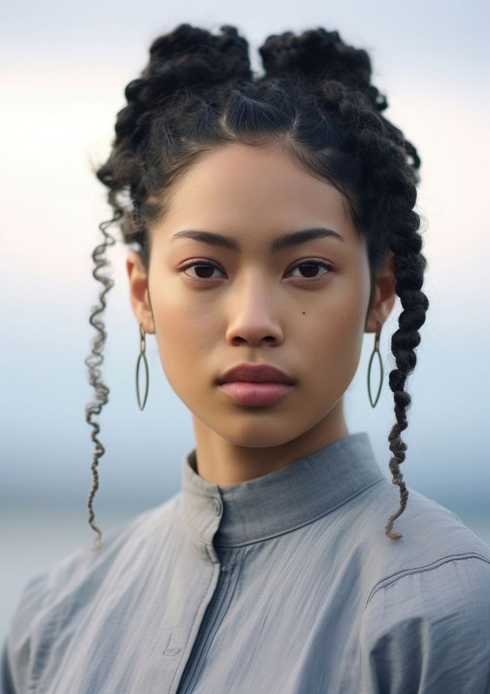 A Pacific Islander woman with original hair style portrait braid contemplation.