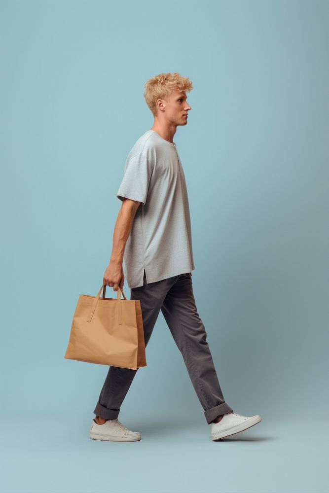 A man with tote bag walking handbag person.