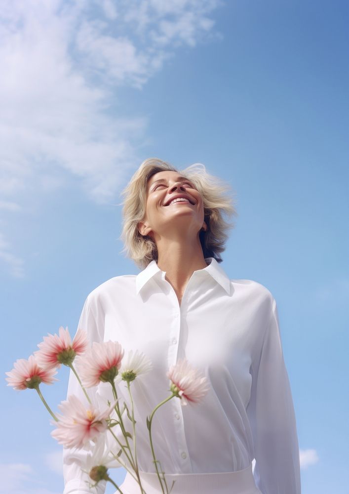 Happy Mature woman wearing white outfit portrait outdoors flower.
