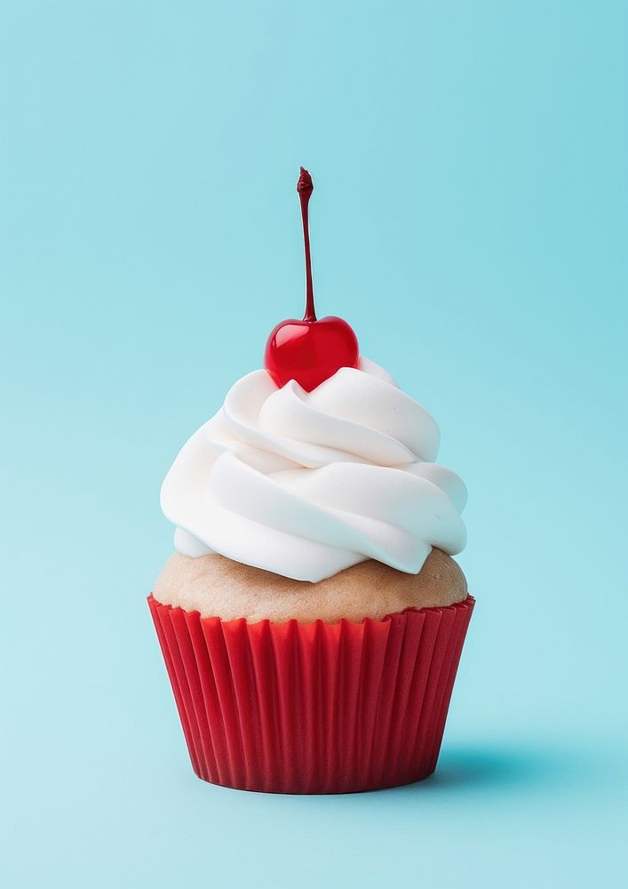 A cupcake with whipped cream and a cherry on top dessert food blue. AI generated Image by rawpixel.